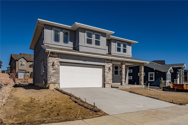 prairie-style home with a garage, stone siding, concrete driveway, and stucco siding