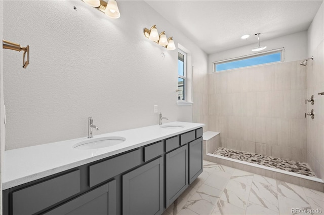 full bathroom featuring marble finish floor, a walk in shower, and a sink