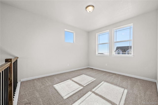 spare room featuring carpet and baseboards