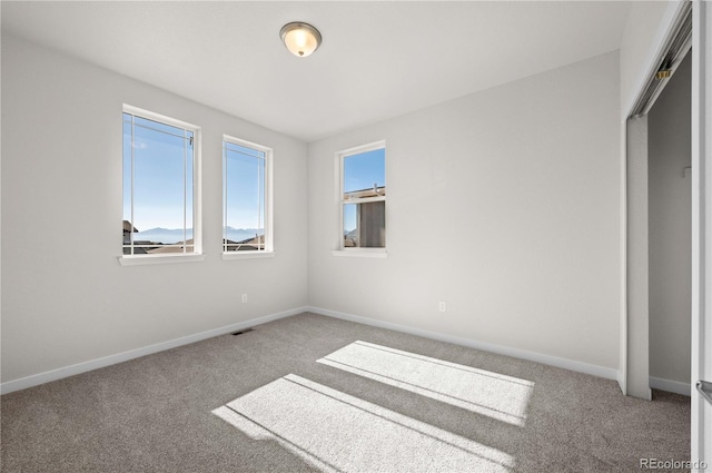 unfurnished bedroom featuring visible vents, baseboards, and carpet flooring