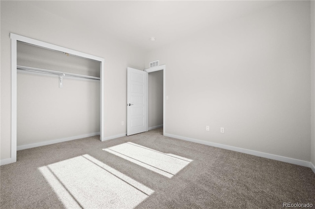 unfurnished bedroom featuring carpet, a closet, visible vents, and baseboards