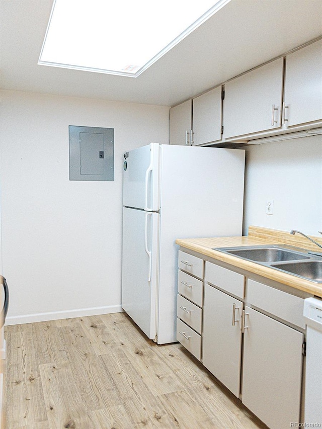 kitchen with white appliances, a sink, white cabinetry, electric panel, and light wood-type flooring