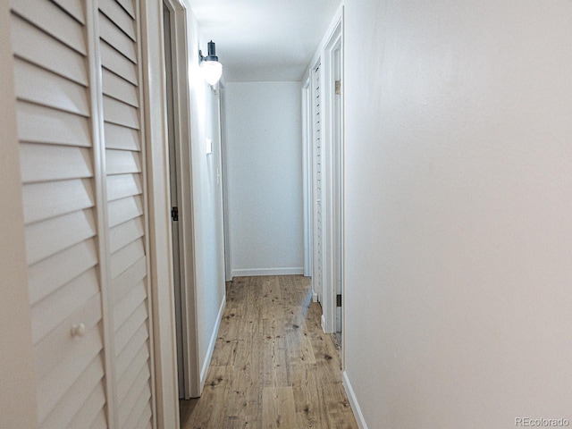 hall with baseboards and light wood-type flooring