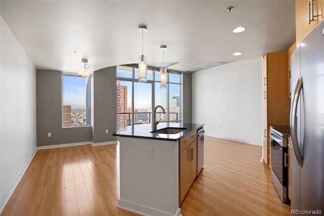 kitchen featuring pendant lighting, sink, appliances with stainless steel finishes, an island with sink, and a healthy amount of sunlight