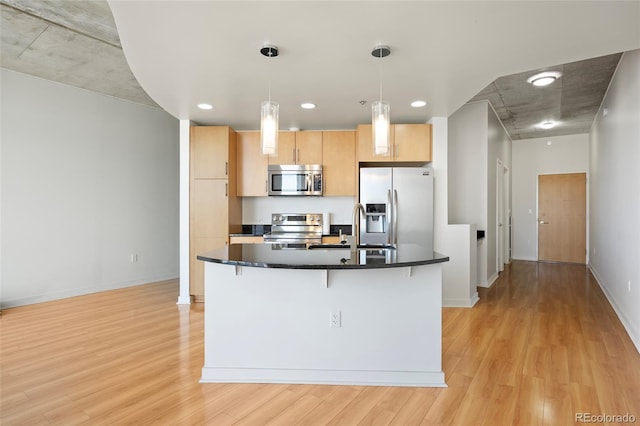 kitchen with sink, light hardwood / wood-style flooring, stainless steel appliances, light brown cabinetry, and decorative light fixtures