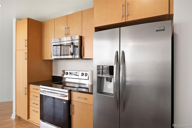 kitchen featuring stainless steel appliances, light brown cabinetry, and light hardwood / wood-style flooring