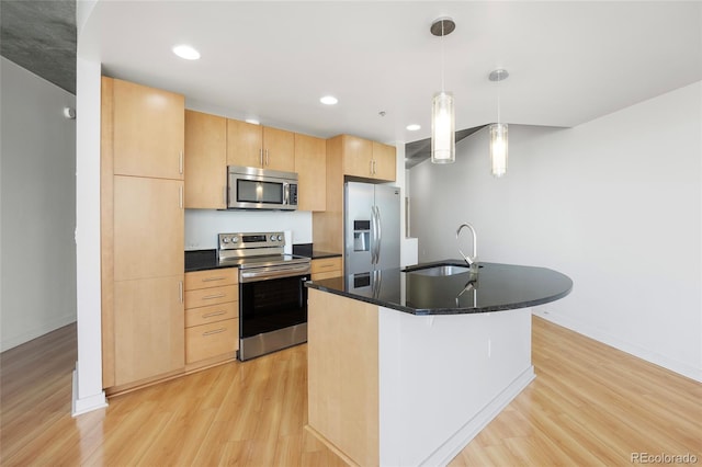 kitchen featuring pendant lighting, sink, stainless steel appliances, light hardwood / wood-style floors, and light brown cabinetry