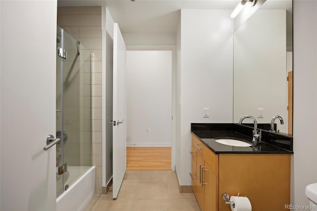 full bathroom with vanity, tile patterned floors, shower / bath combination with glass door, and toilet