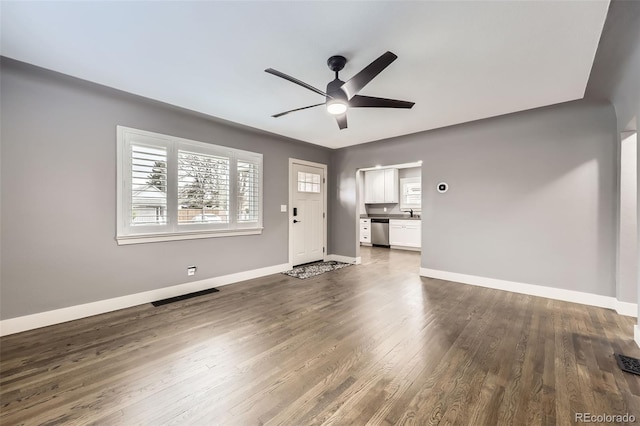 4425 S Lincoln St, Englewood, CO 80113 - unfurnished living room with plenty of natural light, baseboards, ceiling fan, and dark wood finished floors