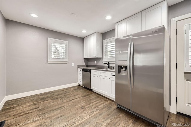 4425 S Lincoln St, Englewood, CO 80113 - kitchen featuring dark wood-style flooring, appliances with stainless steel finishes, a sink, white cabinetry, and baseboards