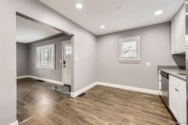 4425 S Lincoln St, Englewood, CO 80113 - kitchen with stainless steel dishwasher, white cabinets, baseboards, and a wealth of natural light