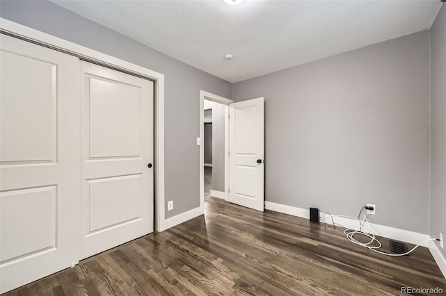 4425 S Lincoln St, Englewood, CO 80113 - unfurnished bedroom featuring baseboards, dark wood-type flooring, and a closet