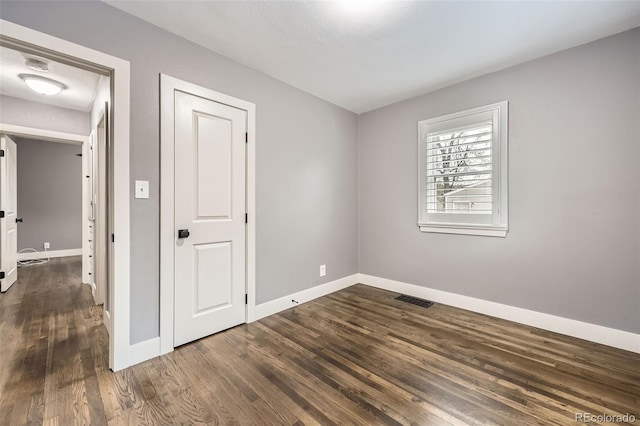 4425 S Lincoln St, Englewood, CO 80113 - unfurnished bedroom featuring baseboards, visible vents, and dark wood-type flooring
