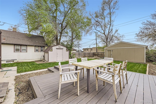 4425 S Lincoln St, Englewood, CO 80113 - wooden deck with fence, a storage unit, outdoor dining space, an outbuilding, and a yard