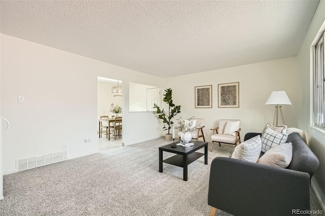 carpeted living room featuring a textured ceiling