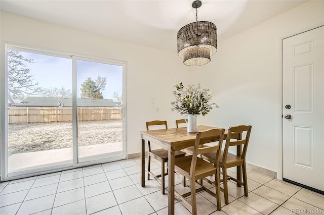 dining space with light tile patterned flooring and an inviting chandelier