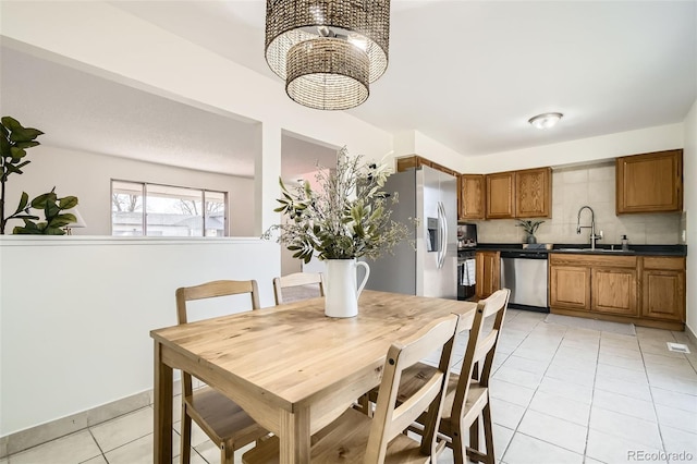 tiled dining space with an inviting chandelier and sink