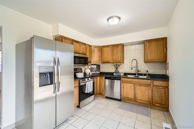 kitchen featuring sink, backsplash, stainless steel appliances, and light tile patterned flooring