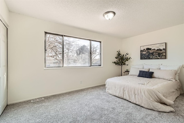 bedroom featuring carpet floors and a textured ceiling