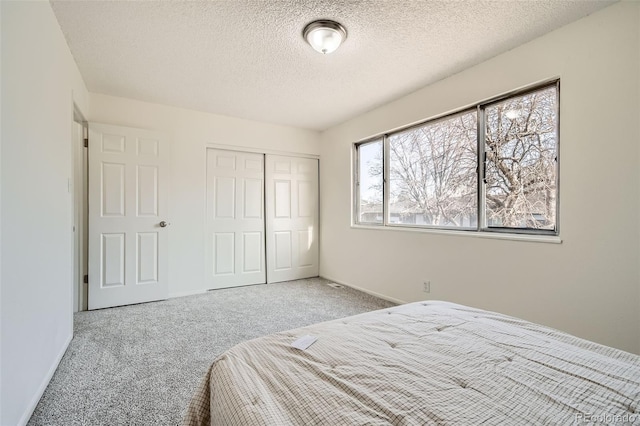 bedroom with carpet floors, a closet, and a textured ceiling