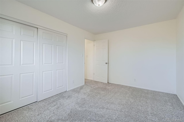 unfurnished bedroom with a closet, carpet, and a textured ceiling