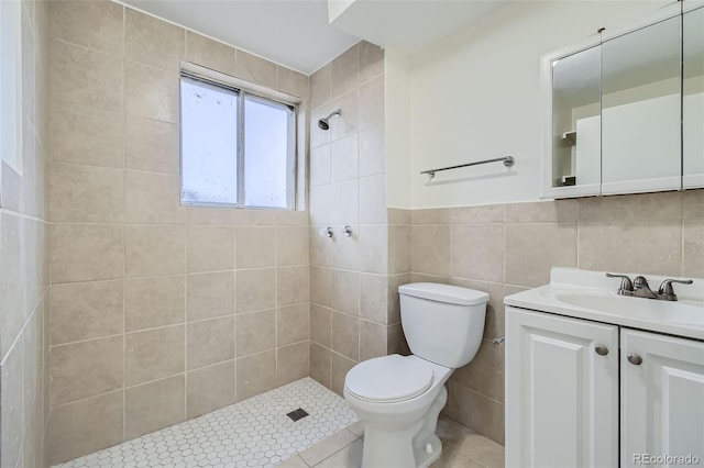 bathroom featuring tile walls, vanity, toilet, and a tile shower