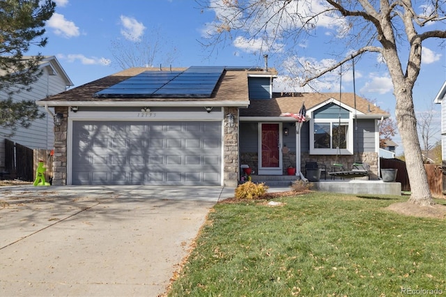 view of front of home with solar panels, a garage, and a front lawn