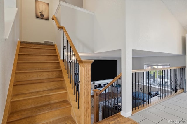 stairs with a high ceiling and visible vents