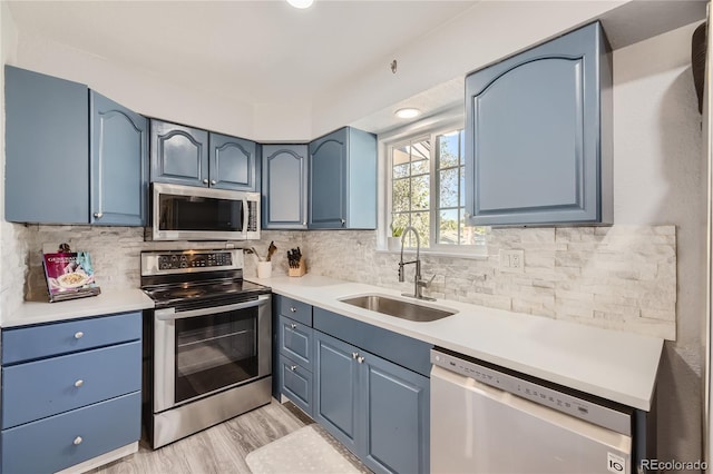 kitchen with sink, blue cabinets, and appliances with stainless steel finishes