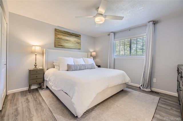 bedroom featuring hardwood / wood-style flooring, ceiling fan, and a textured ceiling