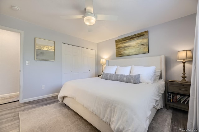 bedroom with ceiling fan, wood-type flooring, and a closet