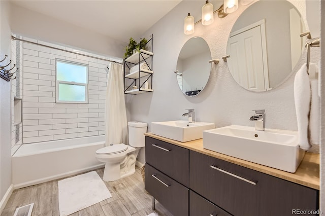 full bathroom with toilet, hardwood / wood-style floors, vanity, and shower / tub combo with curtain