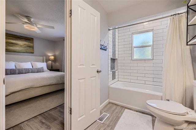 bathroom featuring hardwood / wood-style flooring, ceiling fan, toilet, shower / bathtub combination with curtain, and a textured ceiling