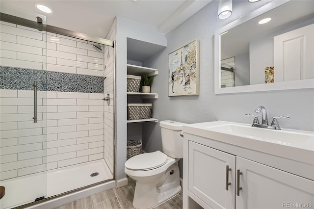 bathroom featuring vanity, hardwood / wood-style flooring, toilet, and walk in shower