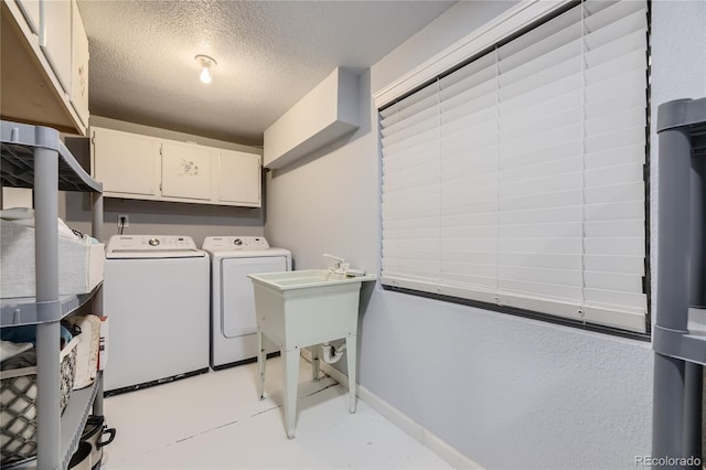 washroom with separate washer and dryer, cabinets, and a textured ceiling