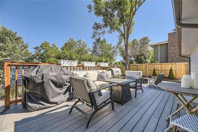 deck with an outdoor living space with a fire pit and a grill