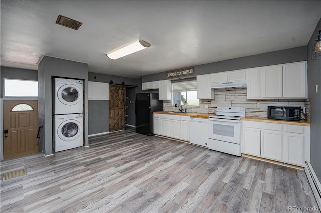 9940 N Calhan Hwy, Calhan, CO 80808 - kitchen with black appliances, stacked washing machine and dryer, a barn door, butcher block counters, and light wood finished floors