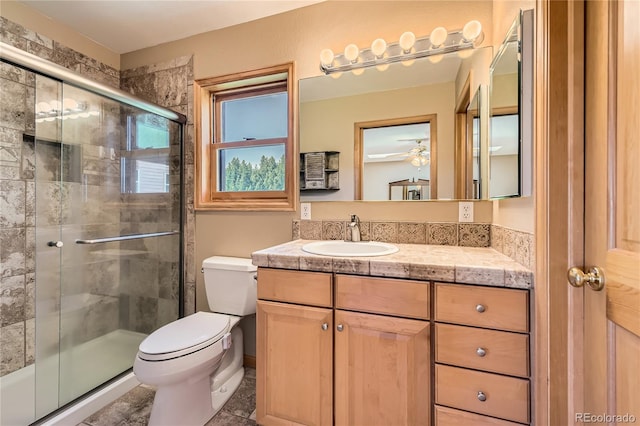 10450 Hondah Dr, Littleton, CO 80127 - bathroom with toilet, a stall shower, vanity, and ceiling fan