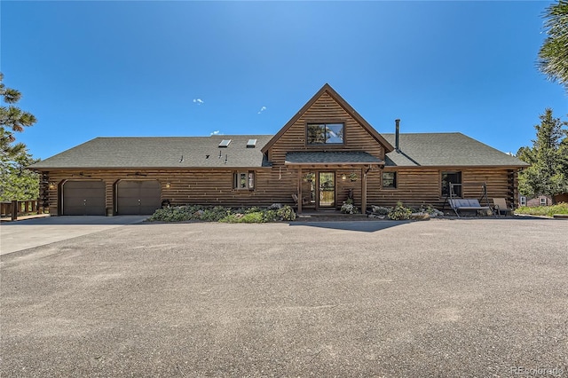 10450 Hondah Dr, Littleton, CO 80127 - log home with log exterior, driveway, a shingled roof, and an attached garage