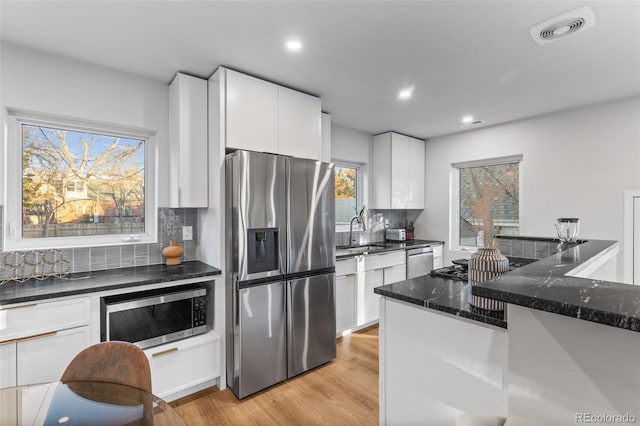 1220 Ash St, Denver, CO 80220 - kitchen with a sink, dark stone countertops, visible vents, white cabinets, and appliances with stainless steel finishes