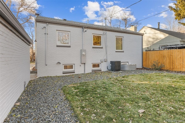 1220 Ash St, Denver, CO 80220 - rear view of property with cooling unit, a chimney, fence, a lawn, and brick siding