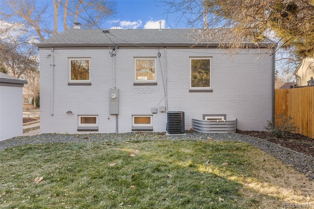 1220 Ash St, Denver, CO 80220 - rear view of property featuring central AC, brick siding, fence, and a lawn