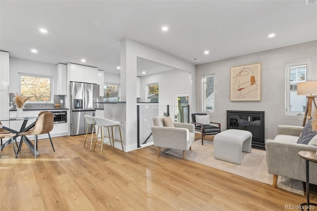 1220 Ash St, Denver, CO 80220 - living room with recessed lighting, a glass covered fireplace, and light wood-style floors