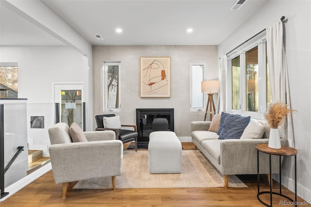 1220 Ash St, Denver, CO 80220 - living area with recessed lighting, a glass covered fireplace, visible vents, and wood finished floors
