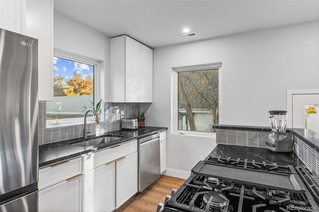 1220 Ash St, Denver, CO 80220 - kitchen with backsplash, visible vents, appliances with stainless steel finishes, and a sink