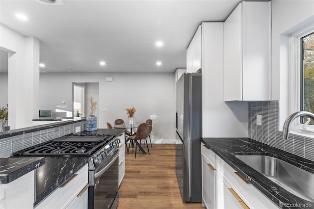 1220 Ash St, Denver, CO 80220 - kitchen featuring a sink, white cabinetry, decorative backsplash, and appliances with stainless steel finishes