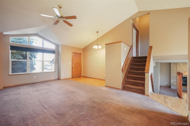 unfurnished living room with light carpet, ceiling fan with notable chandelier, and high vaulted ceiling