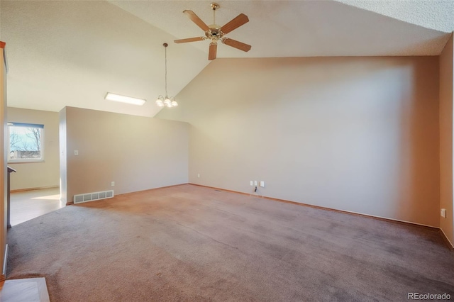 unfurnished living room with high vaulted ceiling, ceiling fan with notable chandelier, and light carpet