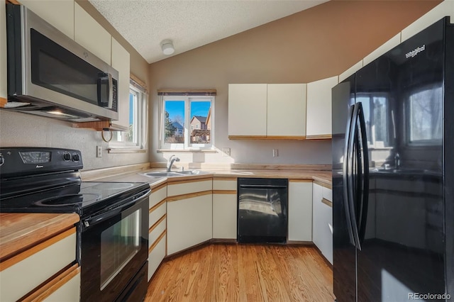 kitchen with white cabinetry, sink, and black appliances