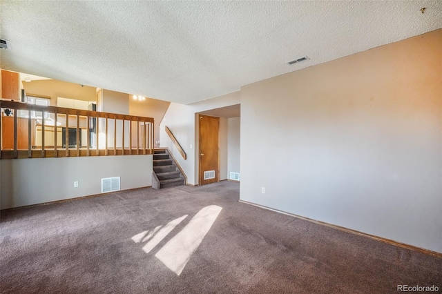 carpeted empty room featuring a textured ceiling